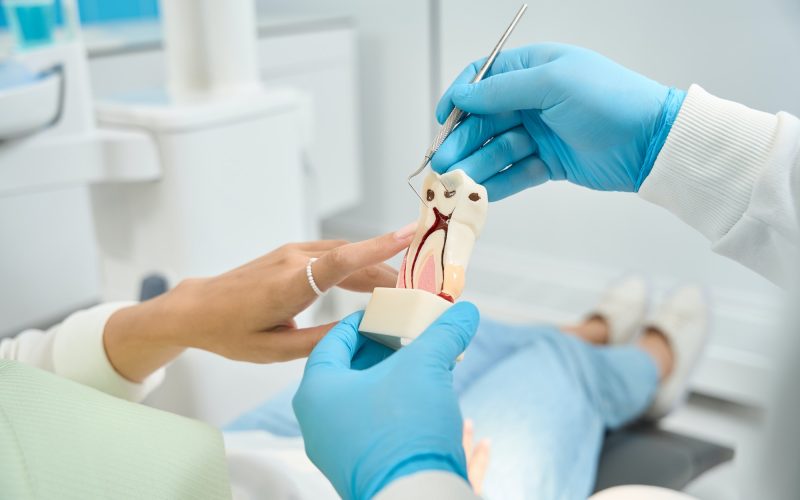 Dentist talking about tooth decay with patient during primary consultation