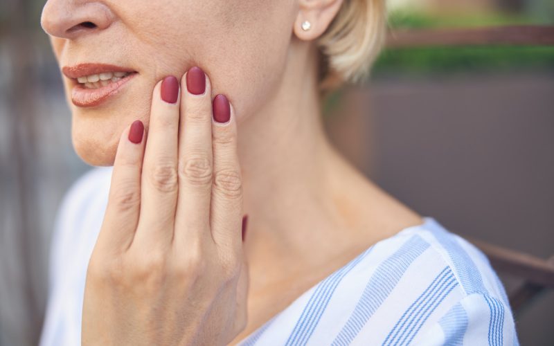 Female suffering from an acute dental pain